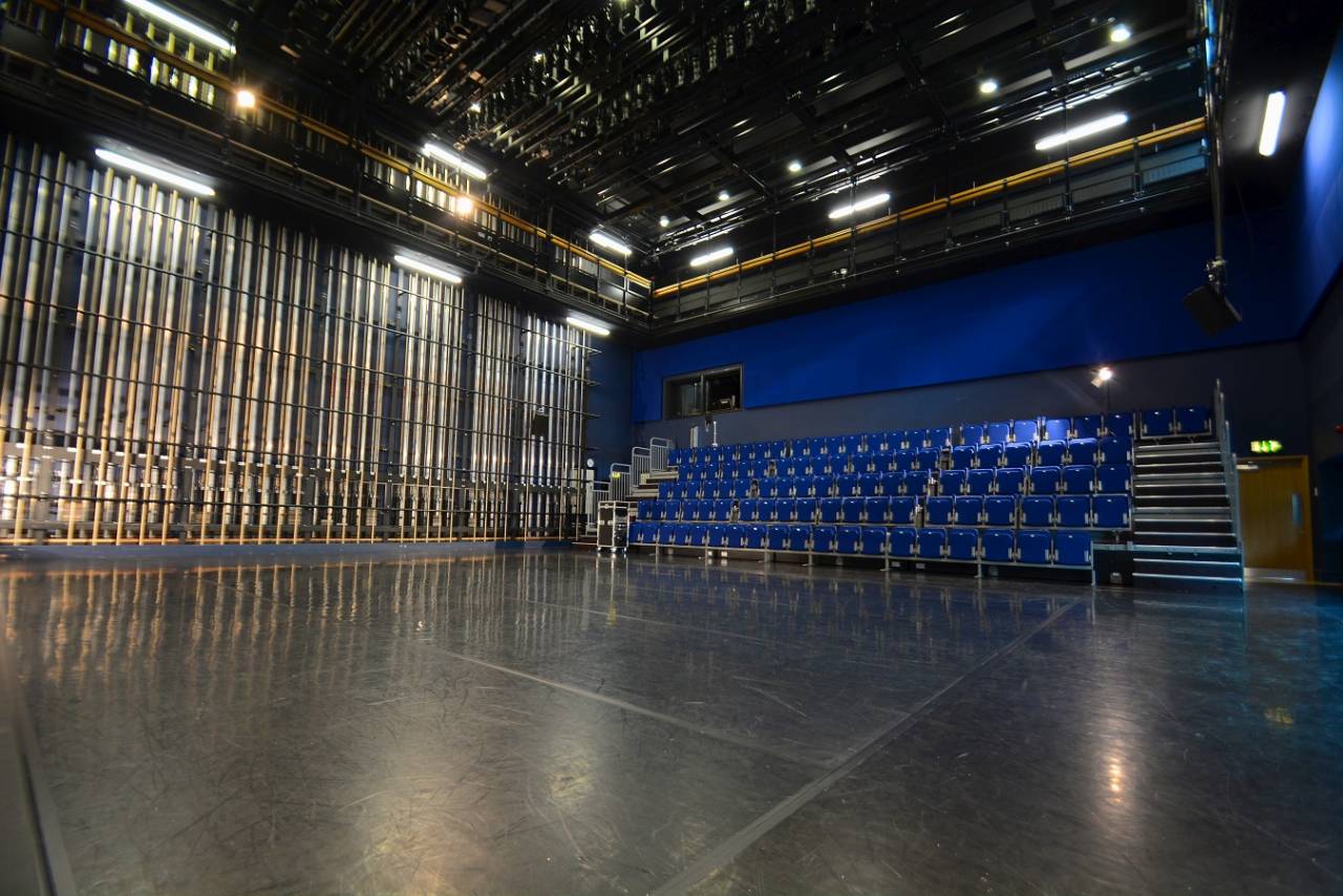 A photograph of the blue room - ti is a large dance studio with blue seats and walls