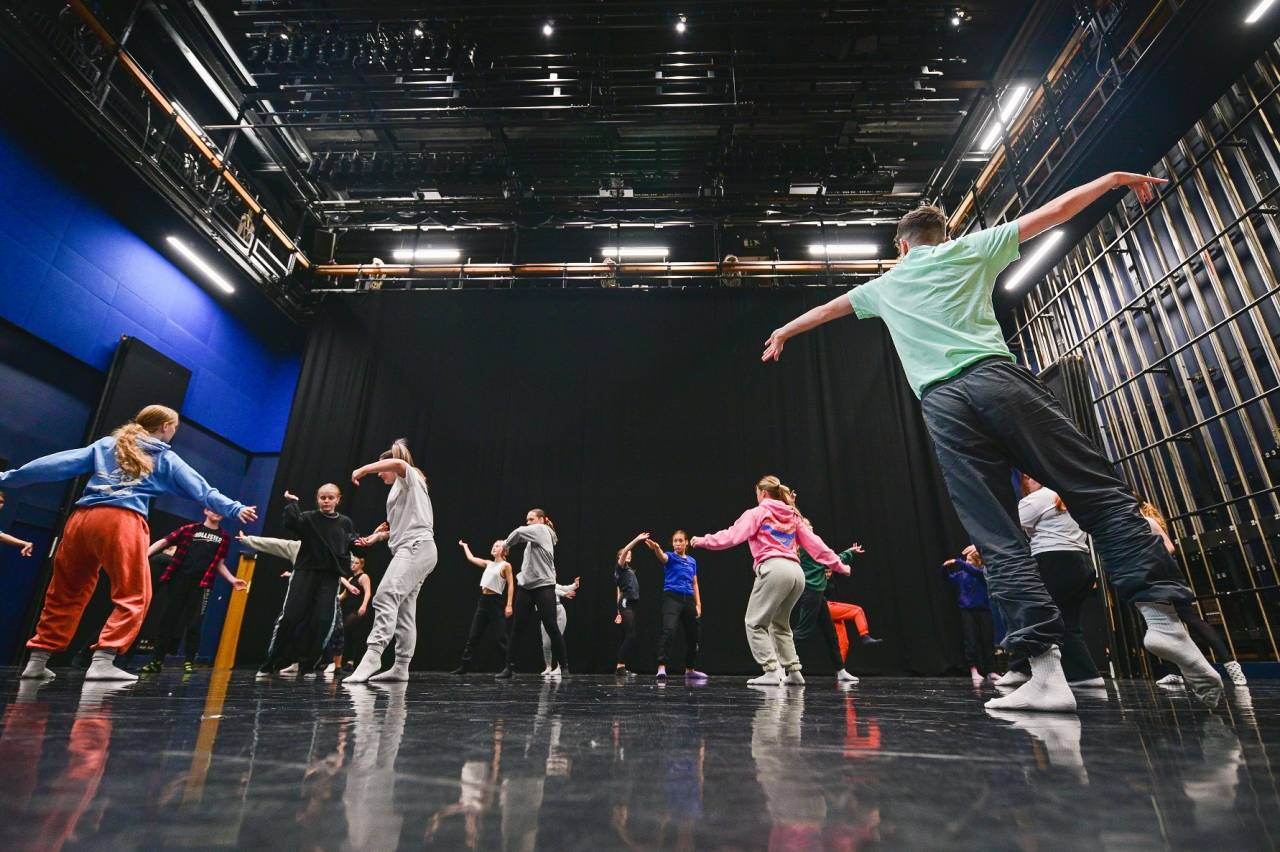 dancers moving in the blue room's open space - in rehearsal clothes