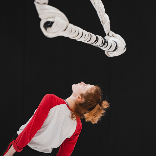 dancer rehearsing under the swinging sculpture 