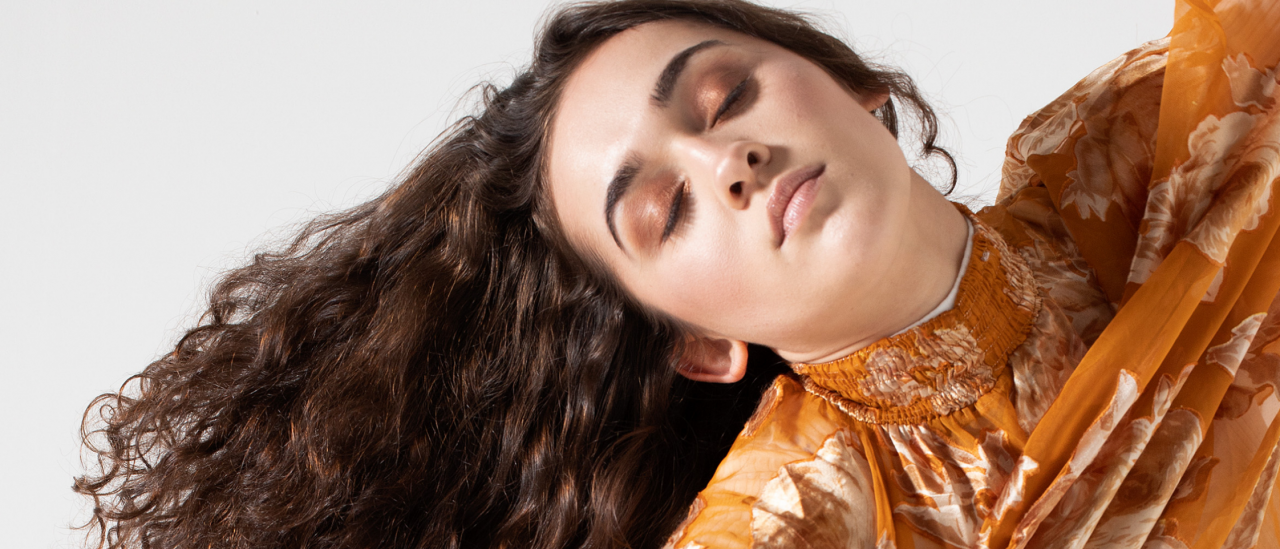 Dancer with brown hair, head to the side and eyes closed