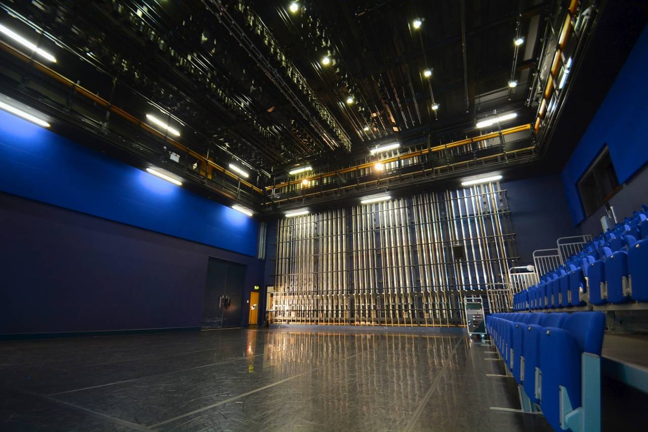 A photograph of the blue room - ti is a large dance studio with blue seats and walls