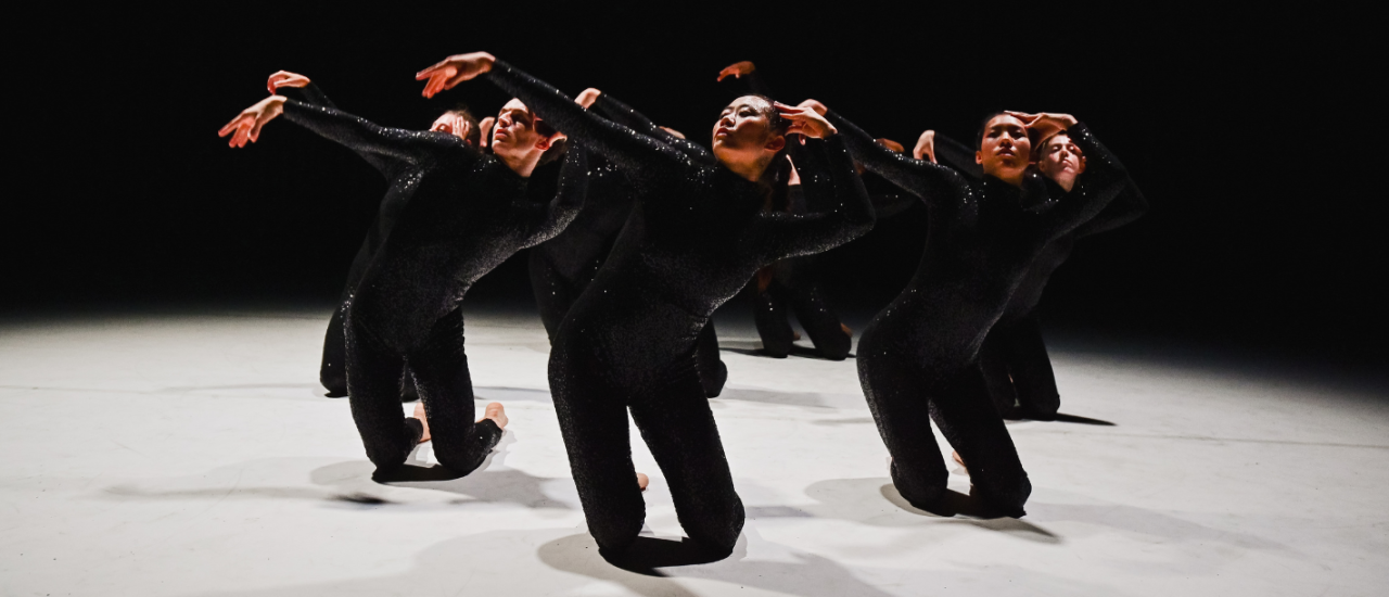 dancers in black sequin costumes moving together