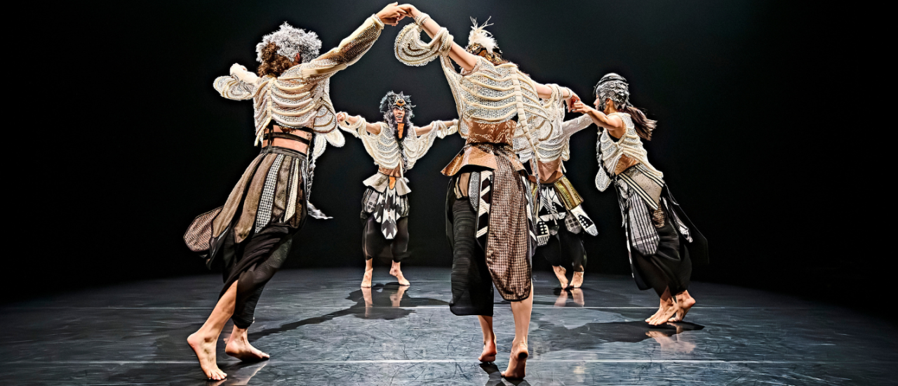 dancers in Osian Meilir's Mabon wear skeleton string vests and dance in a circle, arms raised in celebration