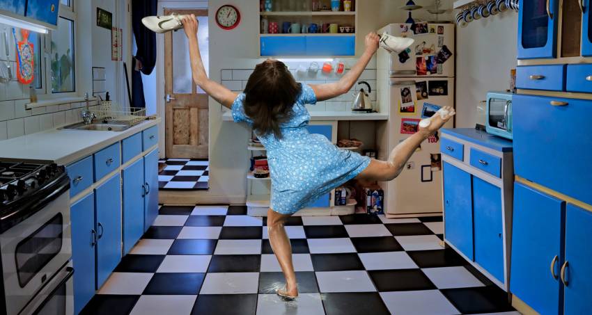 Roots, blue kitchen with dancer facing the back, legs in the air