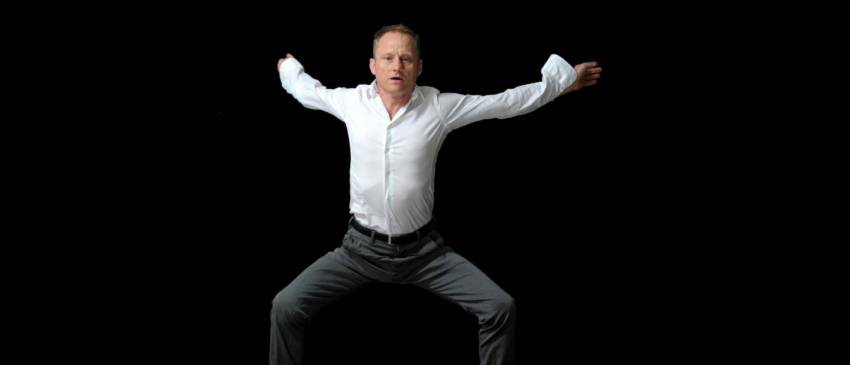 Nigel Charnock jumping in the air on a black background
